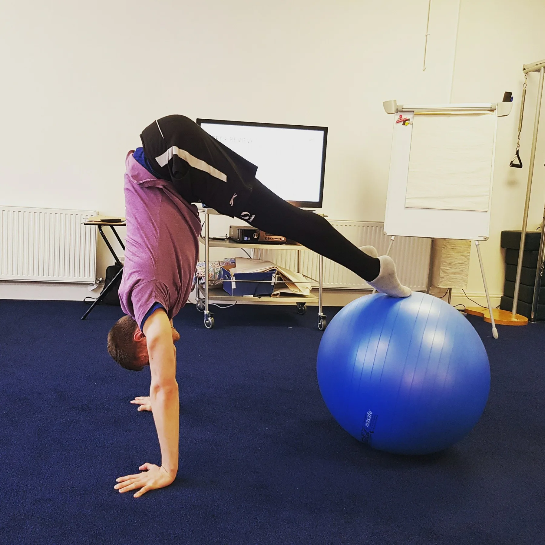 A Start Right Pilates instructor demonstrating an adapted stability-ball exercise