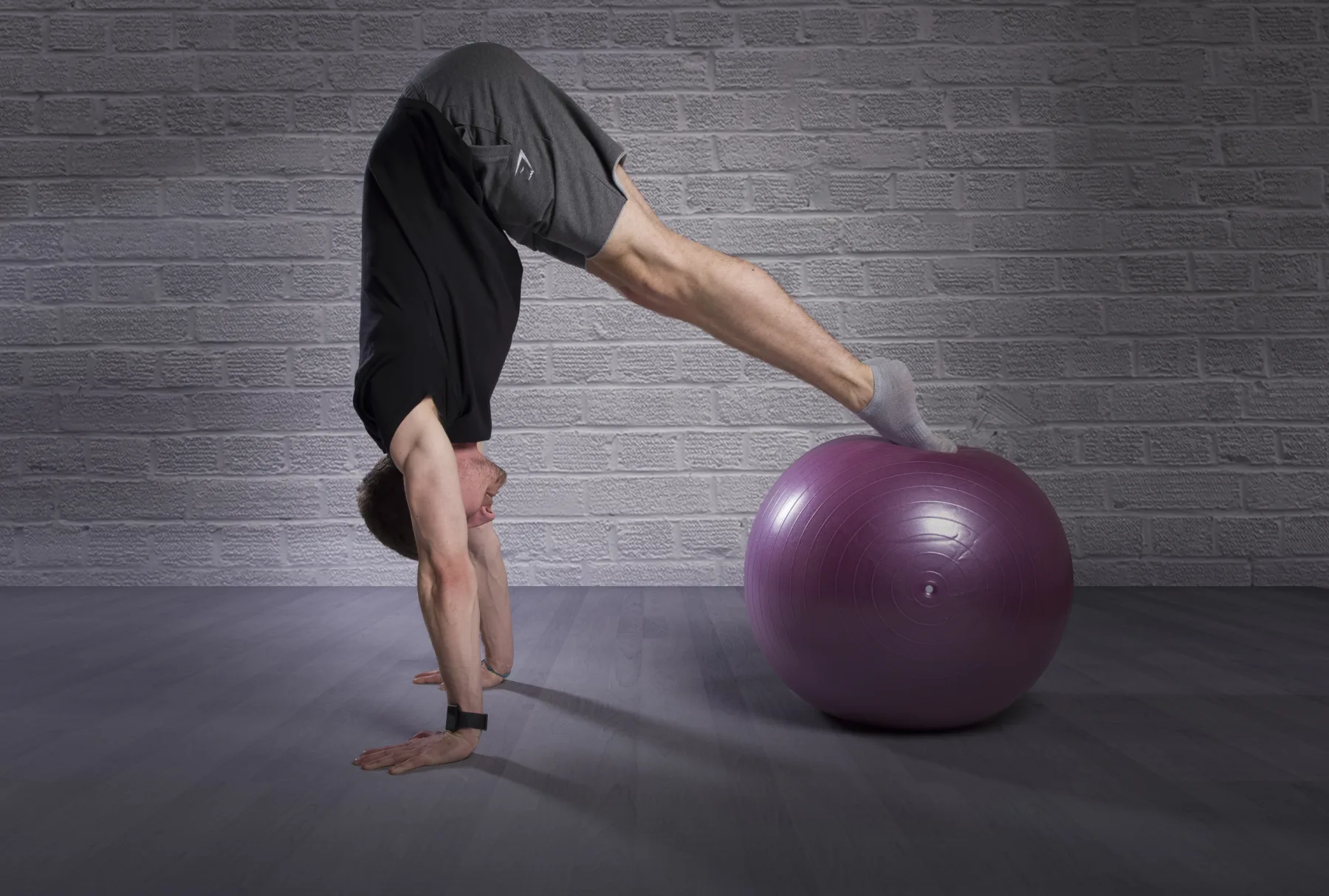 A Start Right Pilates instructor demonstrating a controlled movement with a stability ball
